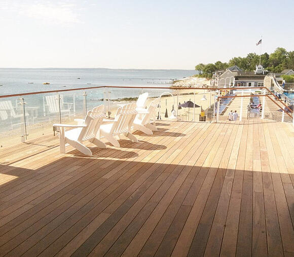 Ipe hardwood deck on the oceanfront  beach with white deck chairs 