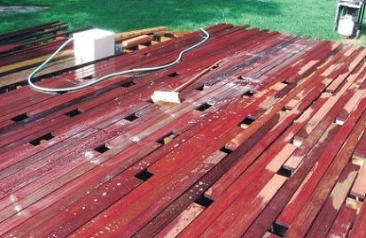 Cleaning_debris_and_dirt_off_the_deck_boards_prior_to_pre-finishing.jpg