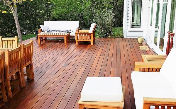 FSC Machiche hardwood deck with dining and entertainment space-1Beautifully varied Machiche hardwood deck with dining and entertainment spaces with white cushions on teak furntiure