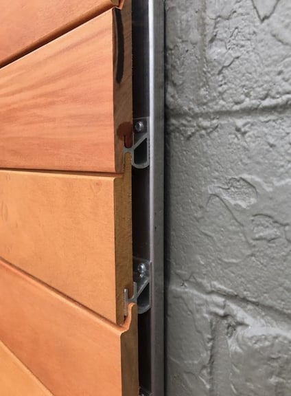 Garapa wood siding fastened with CS2 rainscreen clips to Climate-Shield CSAC8 attachment channel over masonry wall