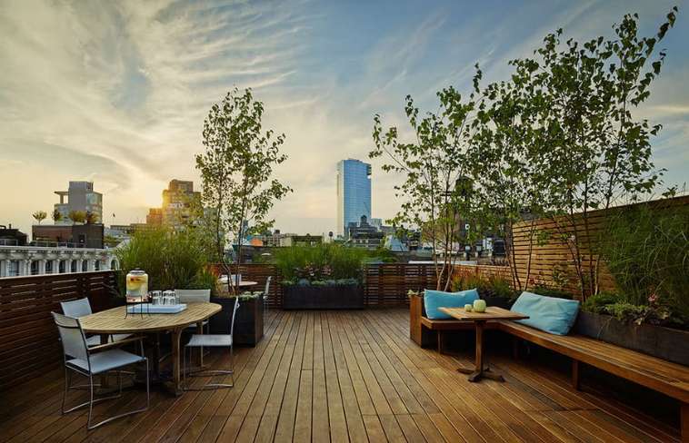 Wood rooftop deck with planters and built in seating and privacy wall in NYC