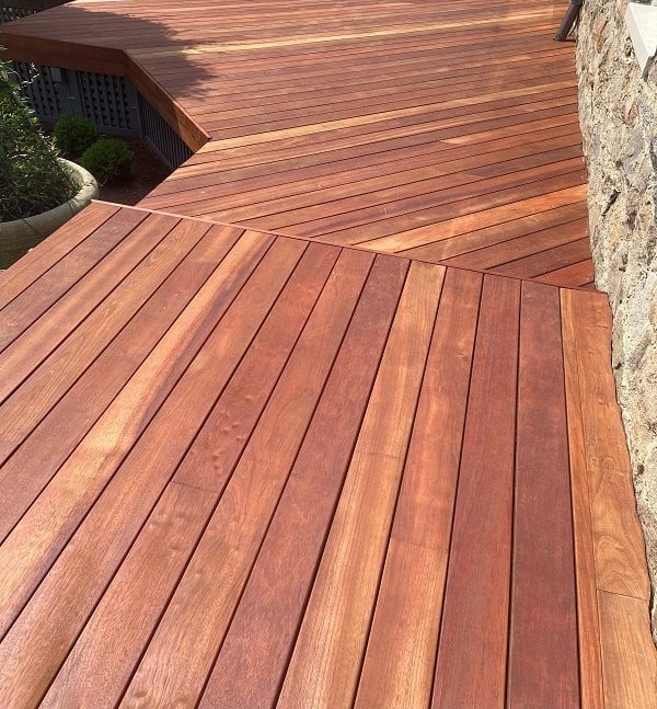 Jatoba hardwood deck cherry red contrasted with stone exterior from Mataverde Decking