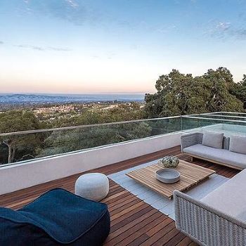 Machiche hardwood rooftop deck with glass railings, cushioned seating and a Machiche custom coffee table overlooking the Bay Area of California