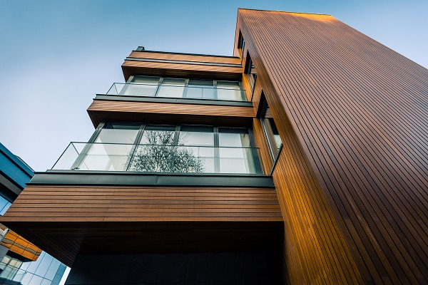 Thermowood rainscreen siding with both vertical and horizontal installation on this home with multiple balconies show off the deep brown tones of the siding material.