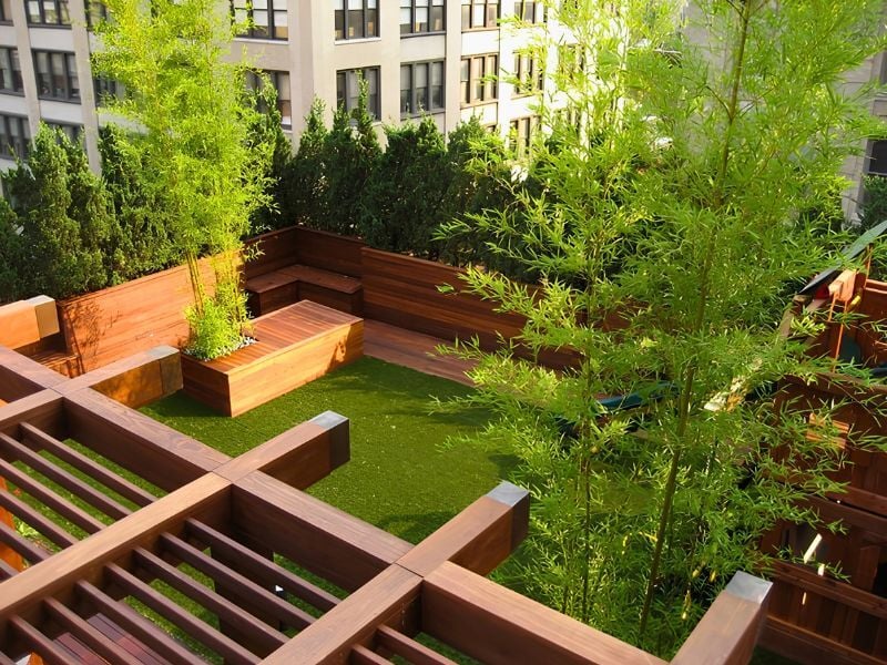 Rooftop deck Ipe wood New York City, view from above including pergola, walkways, built in planters and benches, privacy wall and playscape with turf and greenery