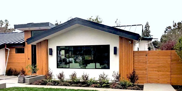 Thermally Modified Hem-Fir siding and fencing contrasts nicely with the white stucco facade around the large front window.,