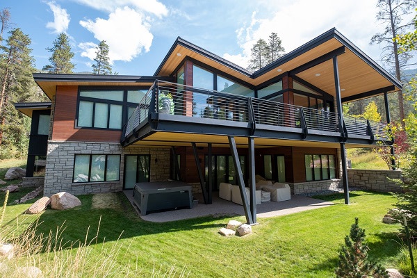 Photo of a contemporary 2 story home with a stone foundation and horizontal wood siding using Mataverde ThermaWood FR on the exterior walls and under the soffits and second floor deck overhangs