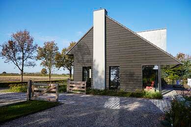 A contemporary home with Trespa Pura NFC® Siding Aged Ash wood decor from Mataverde Sustainable Decking and Siding Solutions.