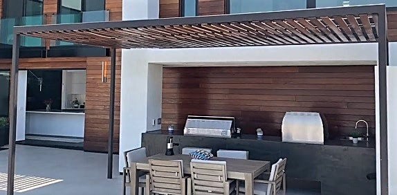 Wood pergola over dining area in outdoor kitchen