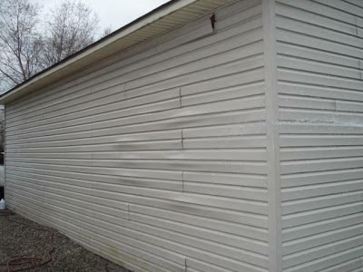Vinyl siding has low resistance to damage and debris, as shown here. Repairs and cleaning are frequently needed to keep it looking its best.