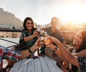 roofto deck people toasting drinks picnic table