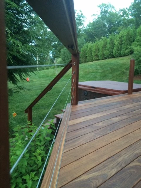 Mataverde Ipe Decking Railing System with Cable Railings in a green lawn backyard with hot tub